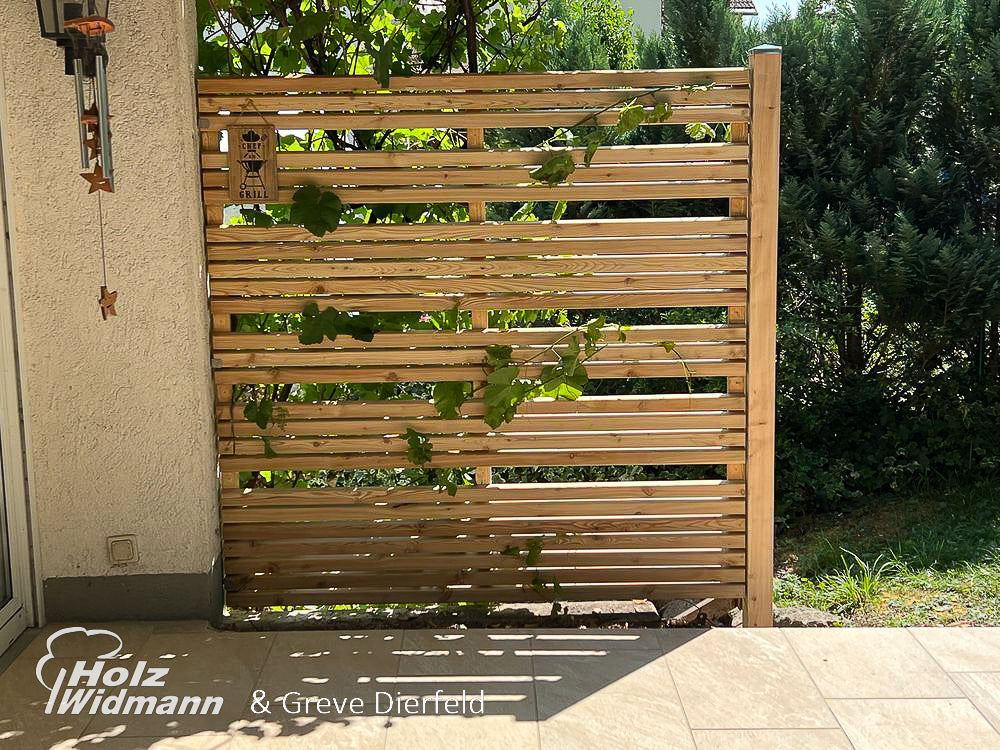 ein Holztor, das neben einem Gebäude steht