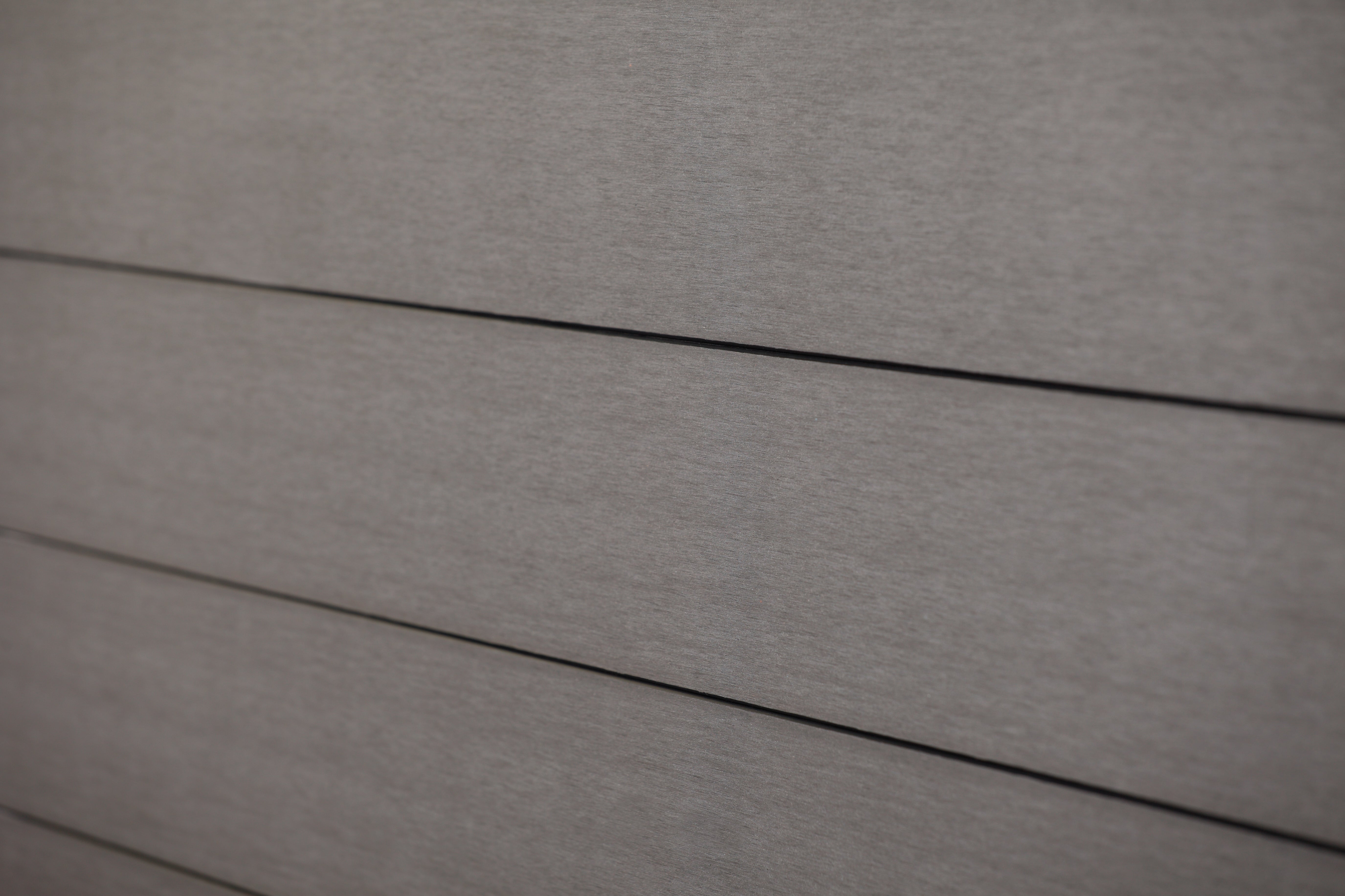 eine Nahaufnahme einer grauen Wand mit einem schwarzen Griff